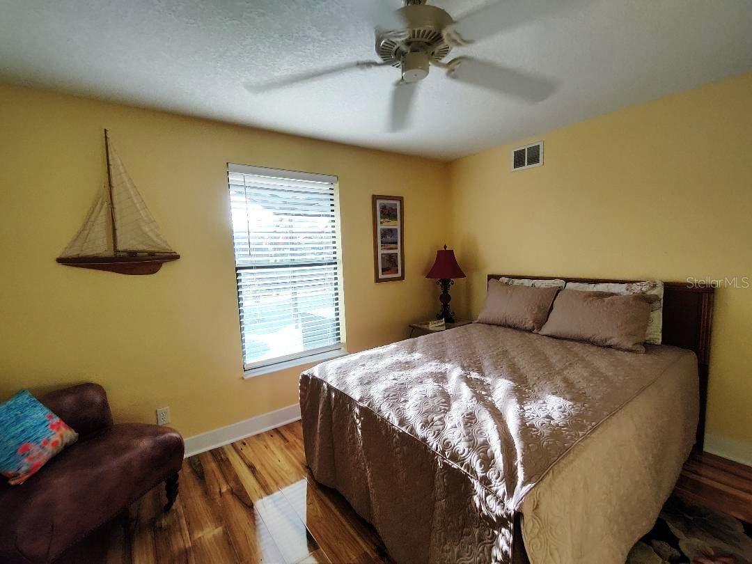 Second bedroom hosts a queen bed and overlooks the pool and dock.