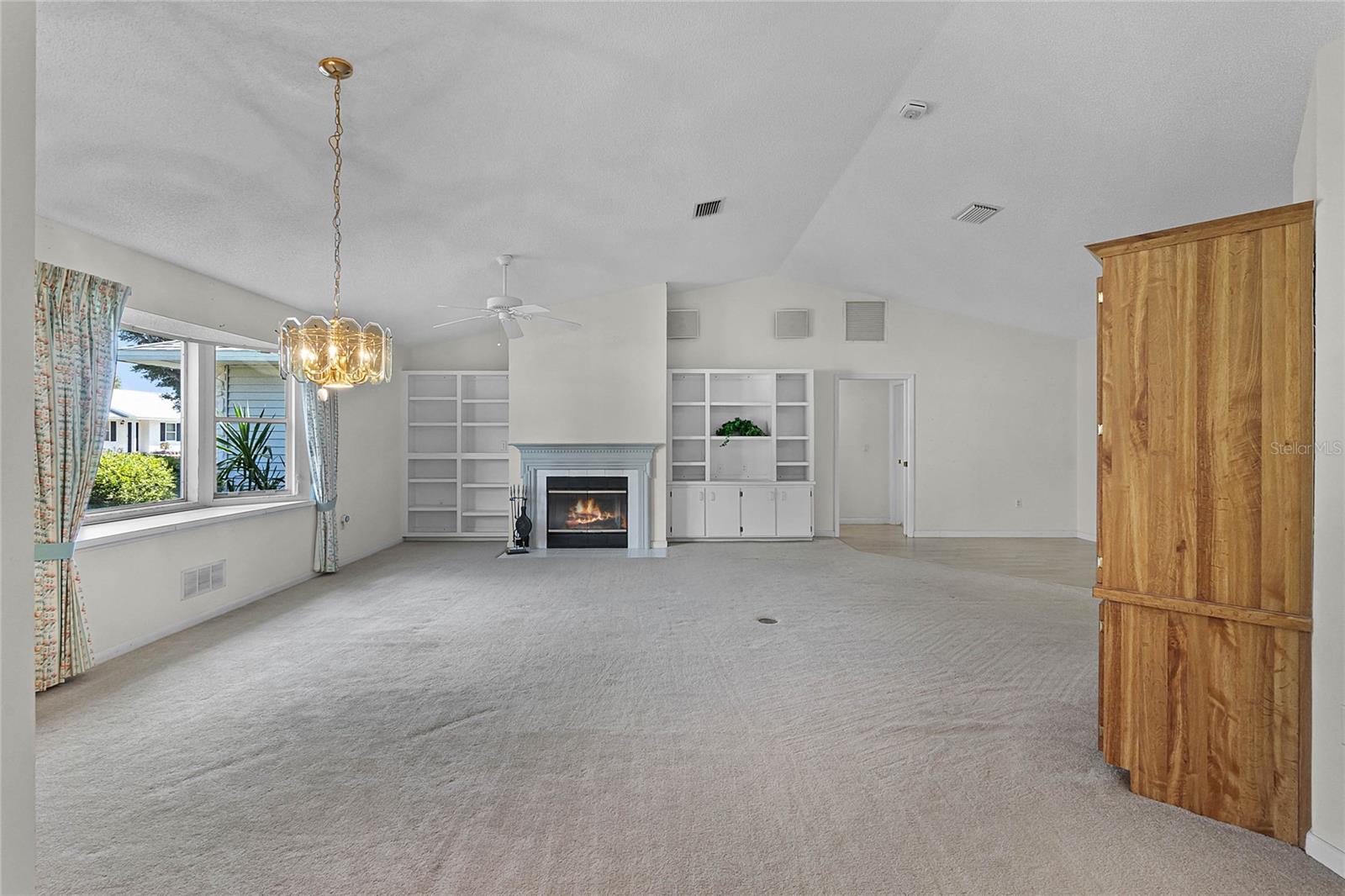 Living Room, located off the front entry/foyer; featuring bay window with storage under seat, wood burning fireplace, built-in's, surround sound speakers.
