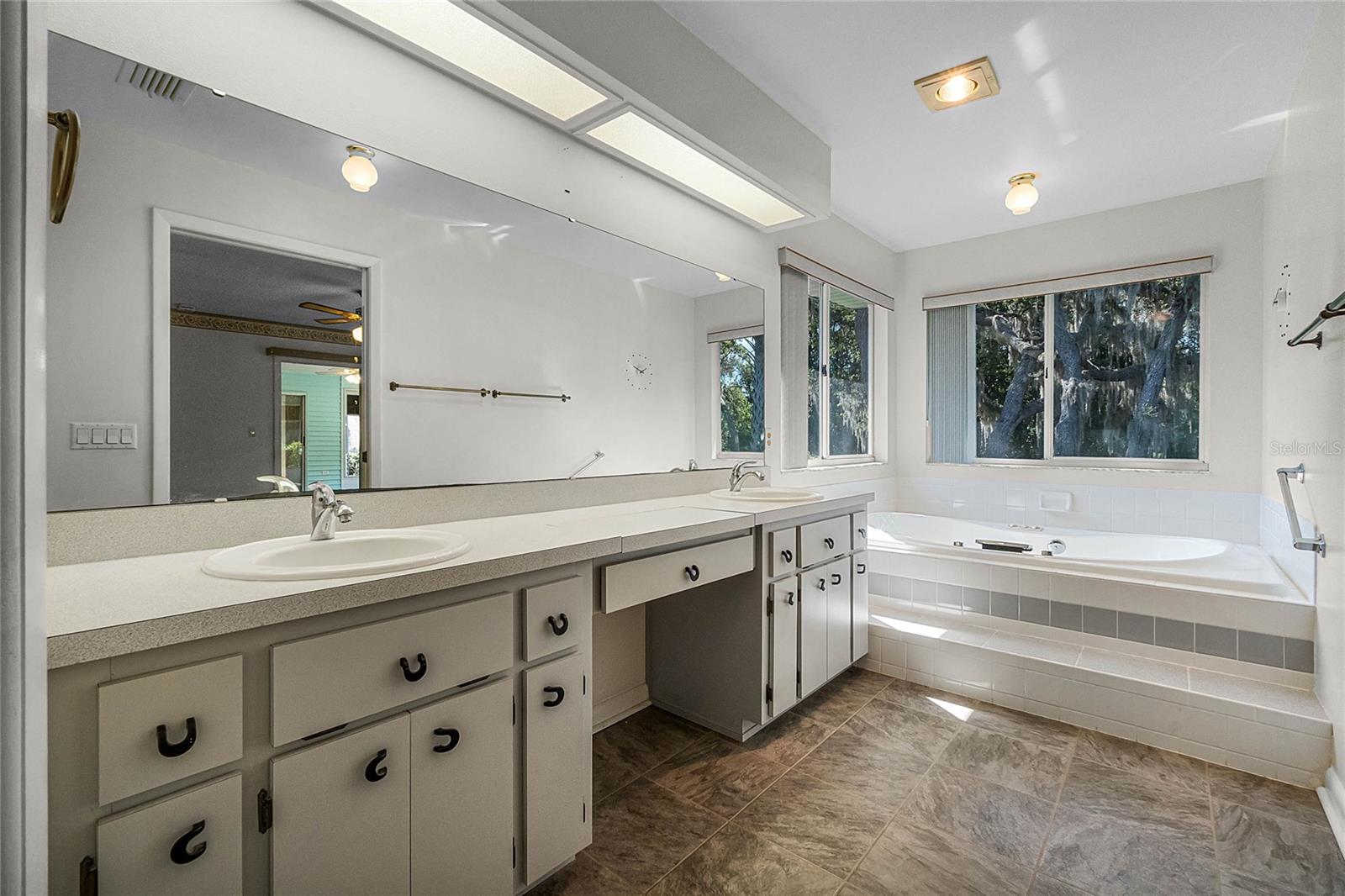Master en suite bath featuring large walk-in closet &amp; laundry chute, jetted soaking tub, dual sinks, built in vanity mirror, separate shower and private water-closet (toilet).