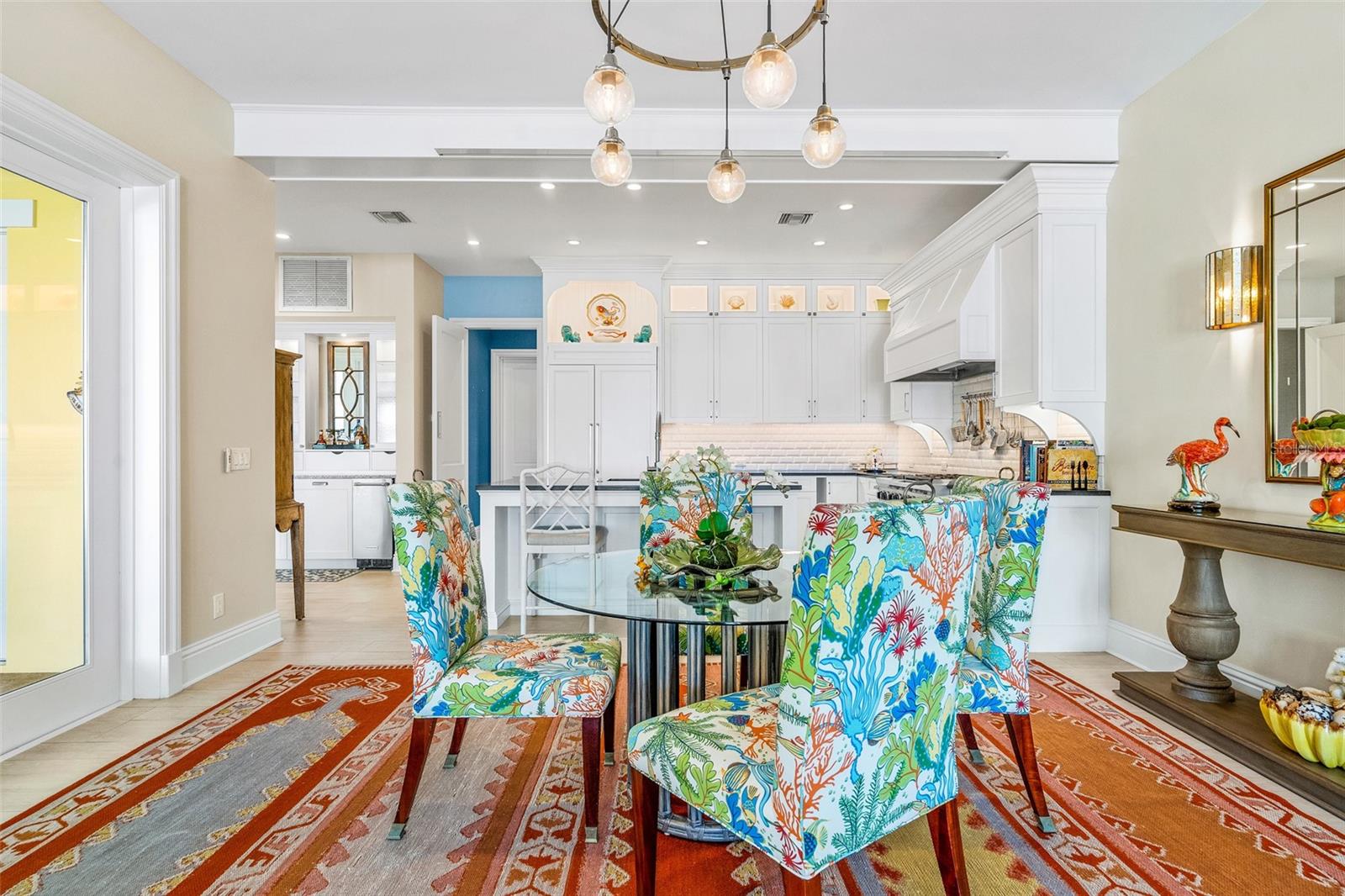Dining with designer chandelier. Frend doors to the courtyard and ease of conversation between the kitchen and the family room.