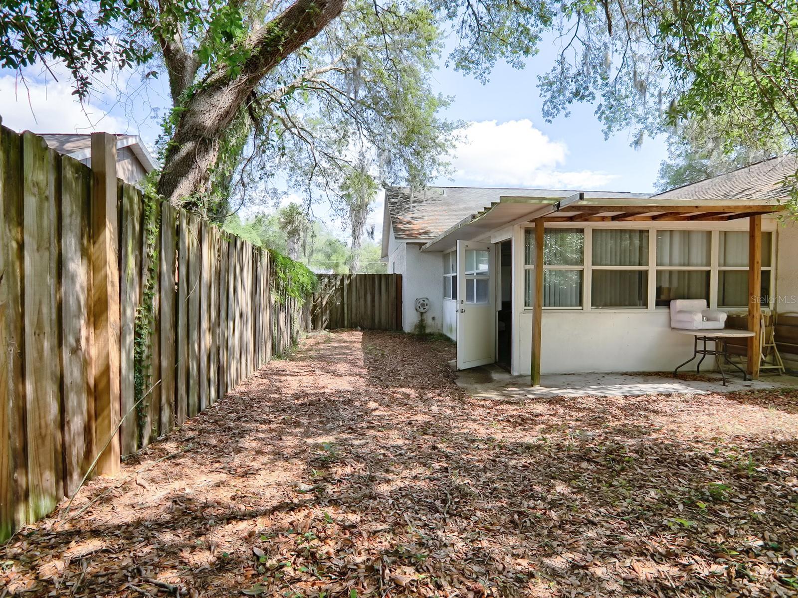 REAR VIEW OF FLORIDA ROOM AND FENCED IN YARD