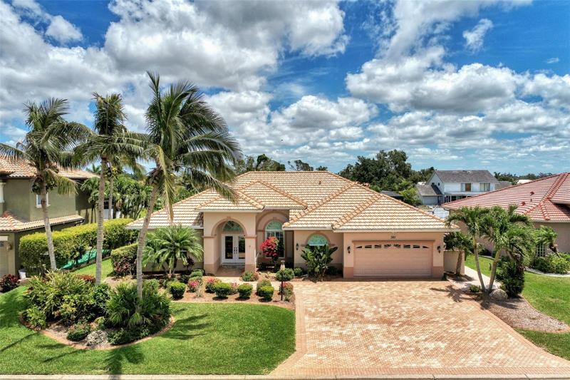 Exclusive boating community of Englewood Isles in Sarasota County. Lush tropical Florida home with paver driveway and barrel tile roof.