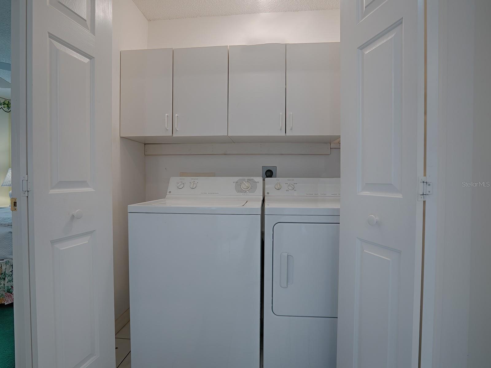 LAUNDRY CLOSET WITH ADDITIONAL CABINETS FOR STORAGE IS IN THE FOYER HALLWAY.