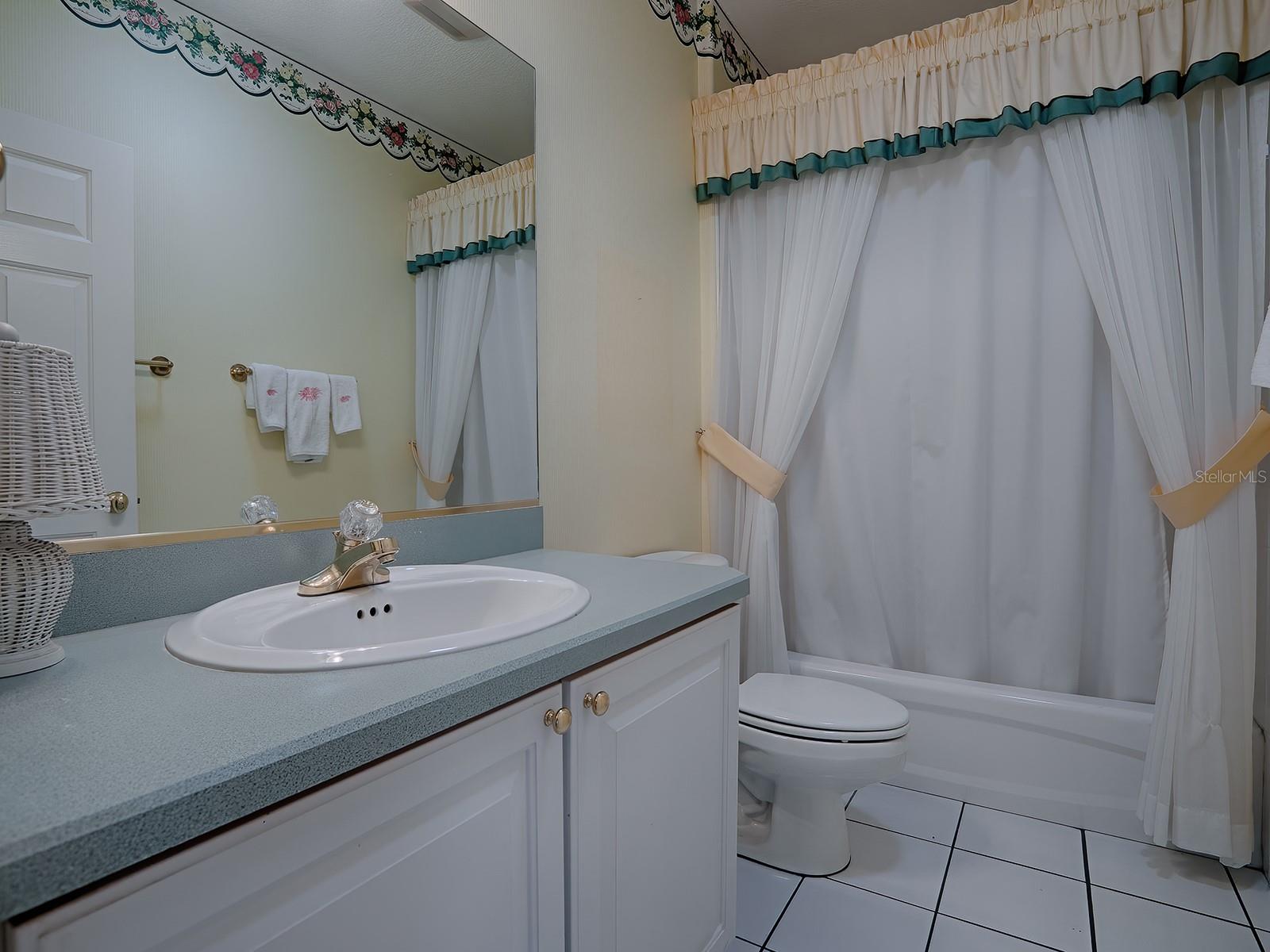GUEST BATHROOM WITH TILE FLOOR AND TUB/SHOWER.