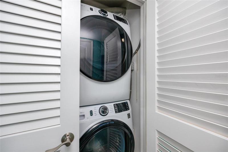 Stackable washer & dryer in the hallway closet.