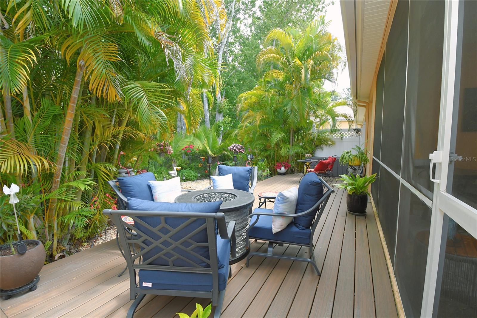 There's an additional outdoor Trex Deck, still under warranty, offering extra seating with a tranquil resort-like view, further enhancing the island paradise vibe.