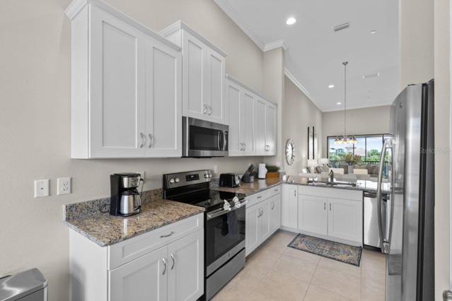 Stunning Kitchen off the front entryway featuring, 12'+ Ceilings, ample cabinetry, granite counter tops, and stainless steel appliances