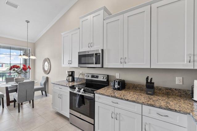 Stunning Kitchen off the front entryway featuring, 12'+ Cathedral Ceilings, ample cabinetry, granite counter tops, and stainless steel appliances