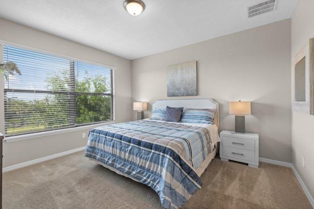 Owners suite off of the living room featuring lake views, en-suite bathroom, and walk-in closets