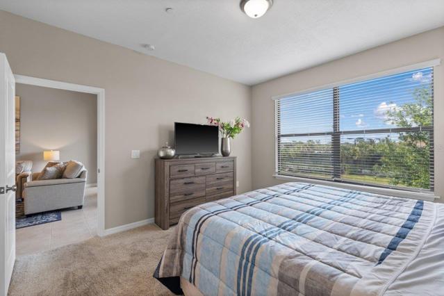 Owners suite off of the living room featuring lake views, en-suite bathroom, and walk-in closets
