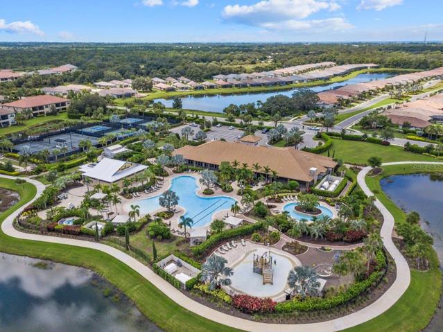 Clubhouse featuring a heated pool, fitness center, lounge, Tiki bar, and tennis courts