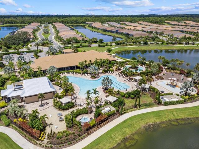 Clubhouse featuring a heated pool, fitness center, lounge, Tiki bar, and tennis courts