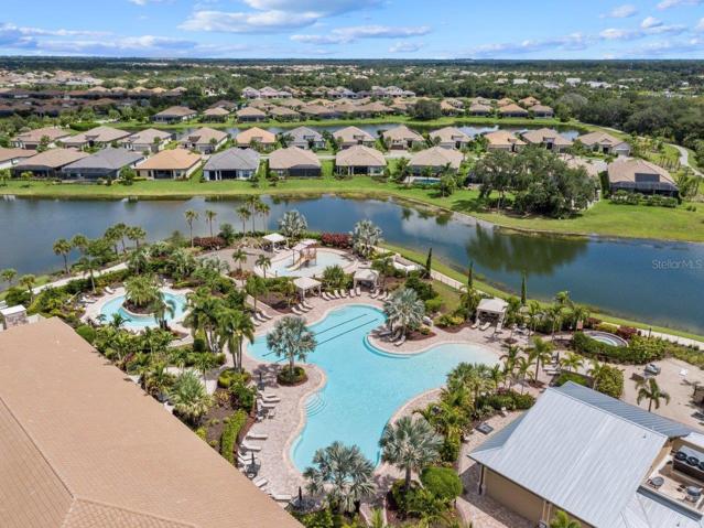 Clubhouse featuring a heated pool, fitness center, lounge, Tiki bar, and tennis courts
