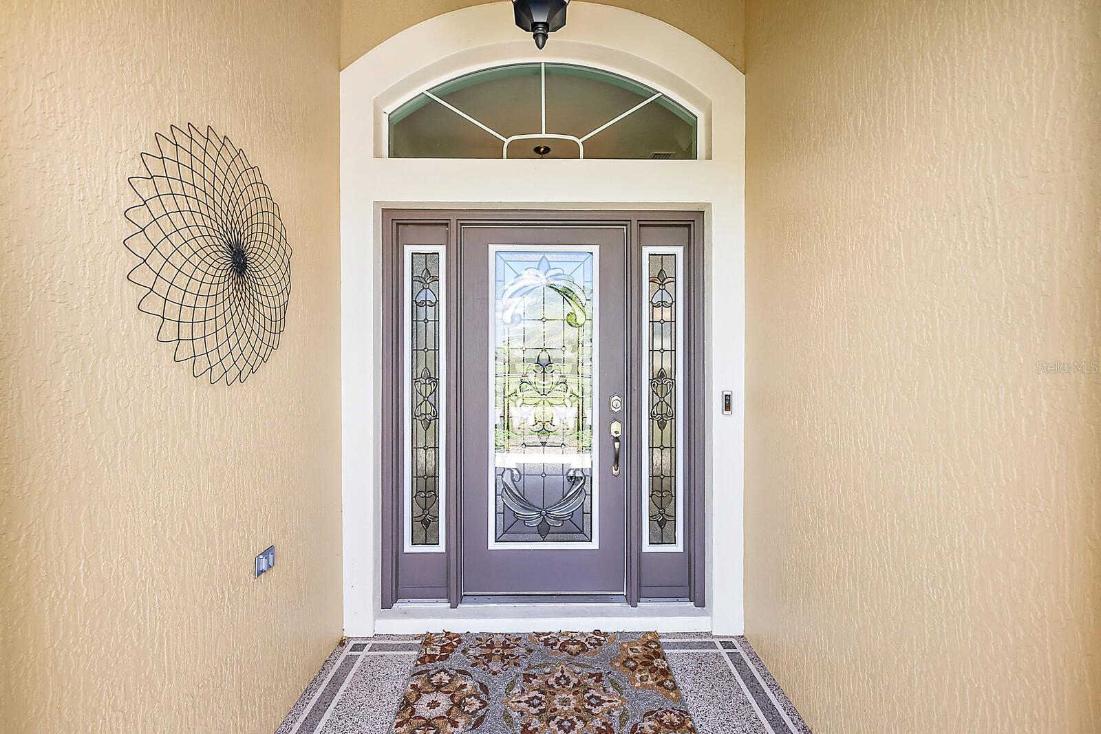 Covered front entrance w/elegant leaded glass door