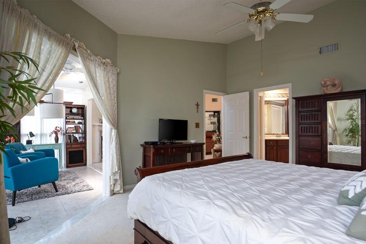 Master Bedroom/Master bath suite with PLANTATION SHUTTER and an abundance of natural light and plenty of room for a large sized furniture set.