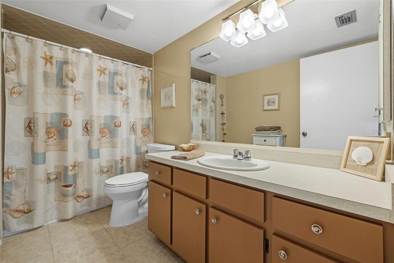 Guest Bathroom - tub shower, tile flooring.