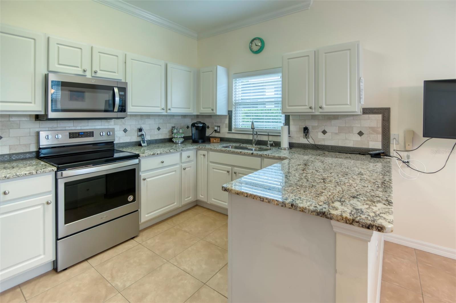 Functional and light kitchen, newer appliances and granite counter, along with custom backsplash and new stainless steel sink