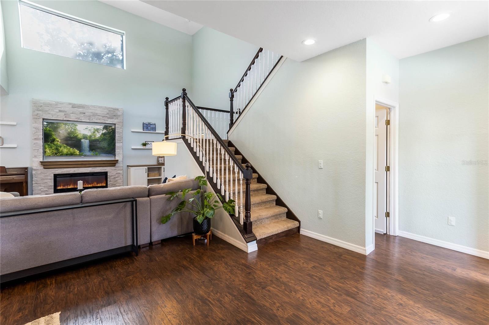 Stairs lead to the upper level, the door next to the stairs leads to the lower level.