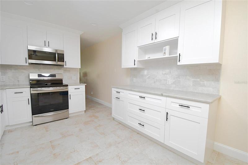Kitchen featuring matching stainless steel appliances. Induction cooktop. Granite countertops. Garbage disposal in the sink. Recessed lighting.