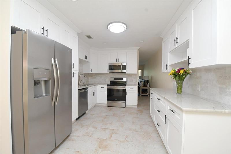 Kitchen featuring matching stainless steel appliances, including an Induction cooktop. Granite countertops. Garbage disposal in the sink. Recessed lighting.