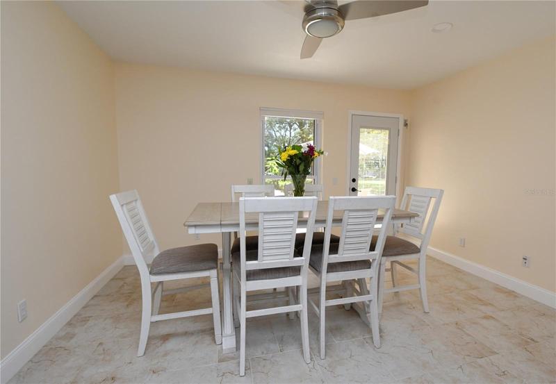 Dining area featuring a ceiling fan with a light. The door provides an access to the back porch/ yard.