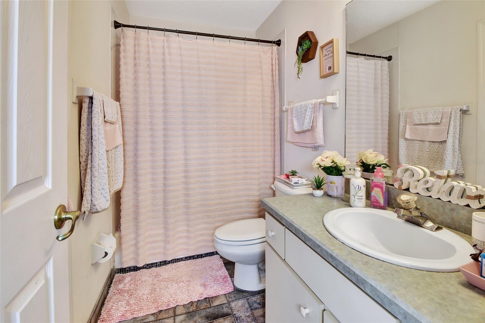 Upstairs bath with door goin into one bedroom and a second door going to the  hallway