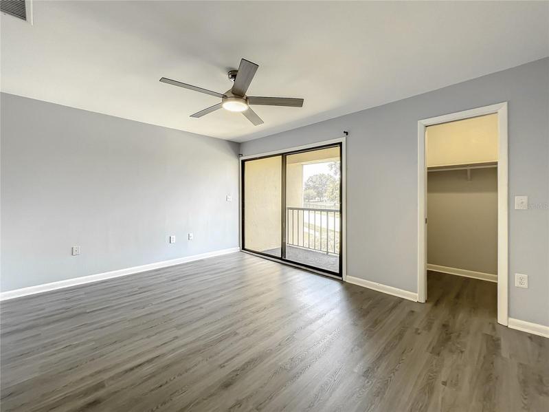 primary bedroom with balcony & walk in closet