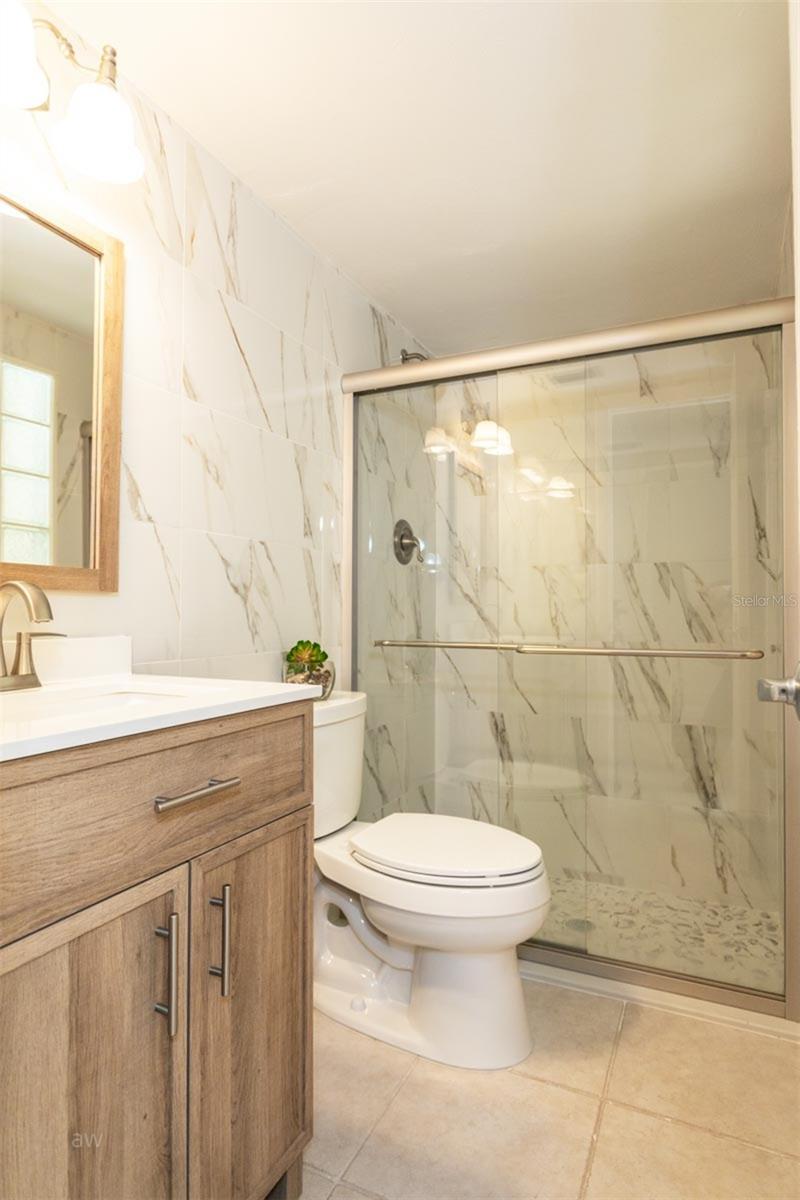Bathroom with gorgeous walk-in tiled shower and new vanity with sink