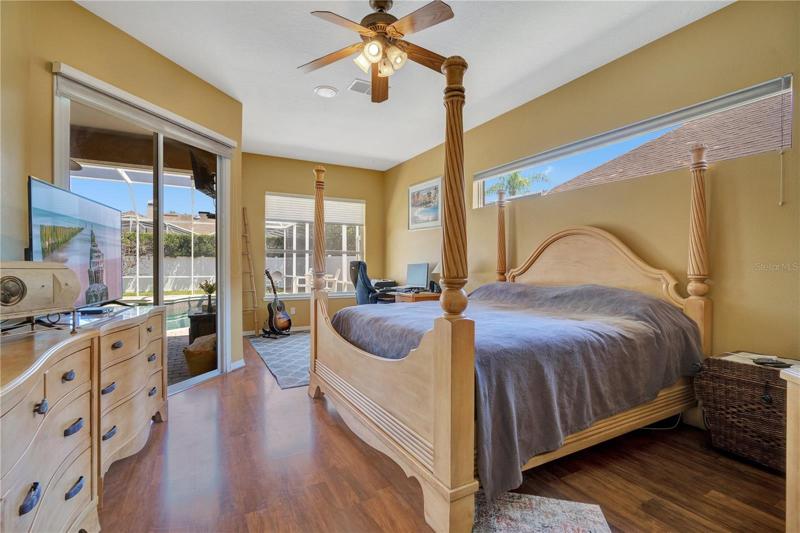 Master retreat with serene views of the privately fence back yard and screened pool and lanai.