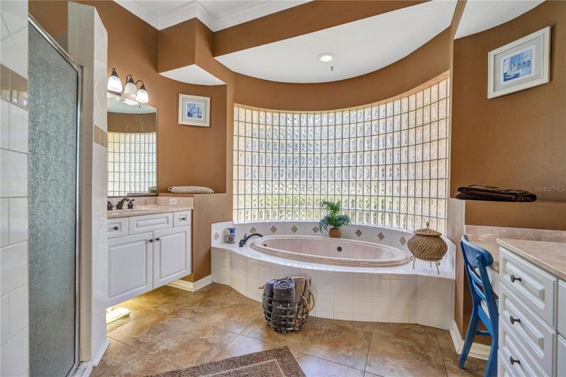 Spa inspired master bath with dual vanities, jetted garden tub and separate shower and bathroom stalls.