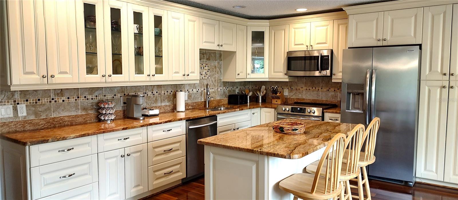 Stunning kitchen with recessed lights, display cabinets, island, newer refrigerator and range