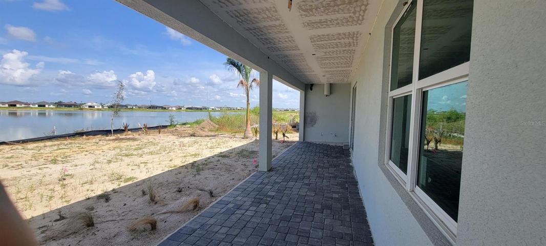 Extended covered lanai with privacy wall and outdoor kitchen prep