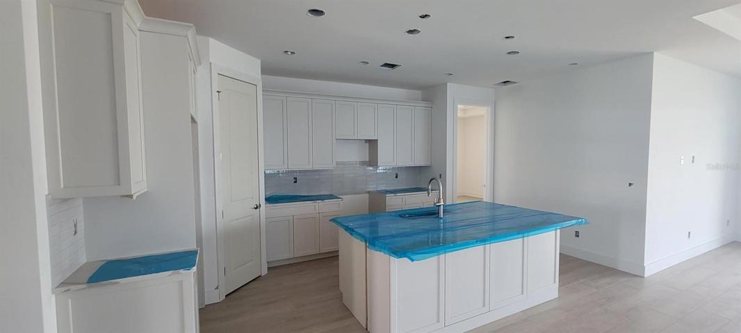 Kitchen with upgraded cabinets and quartz countertops (countertops are protected with blue cover)
