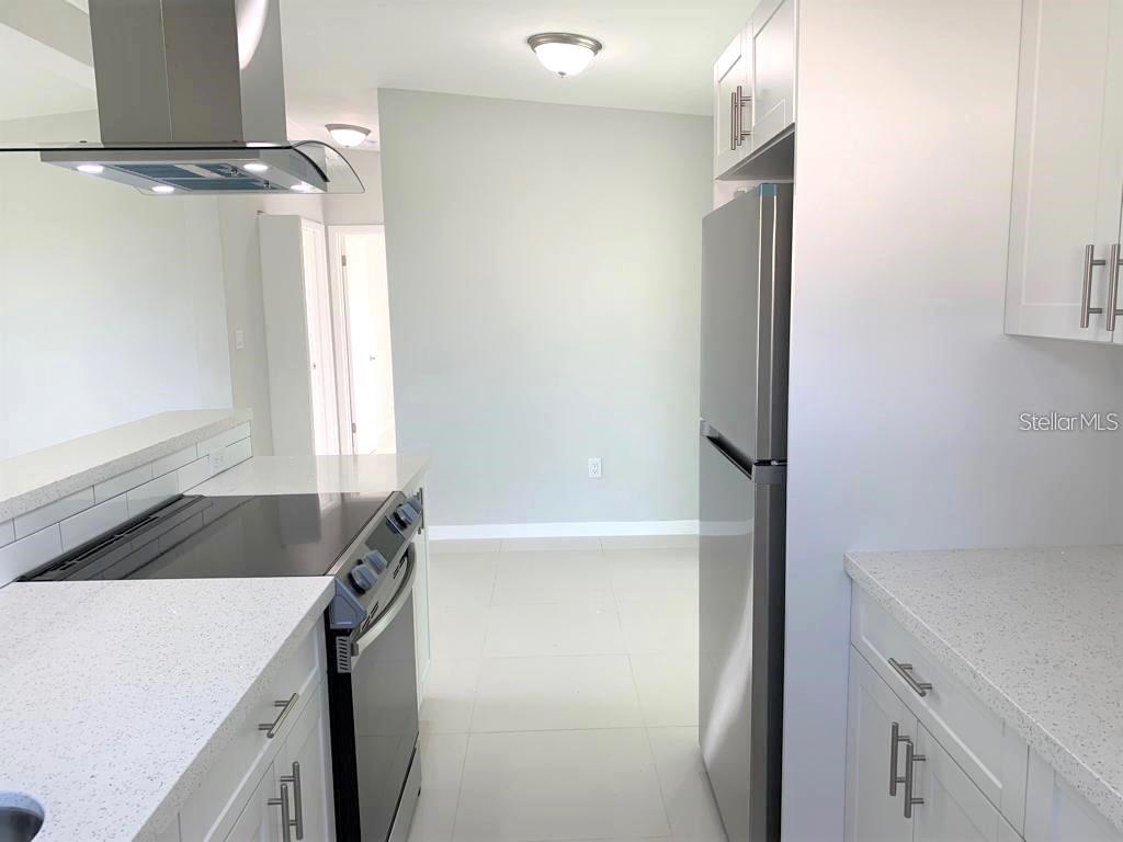 Kitchen features new quartz counters, designer exhaust, stainless steel appliances, real wood cabinets with soft close doors.