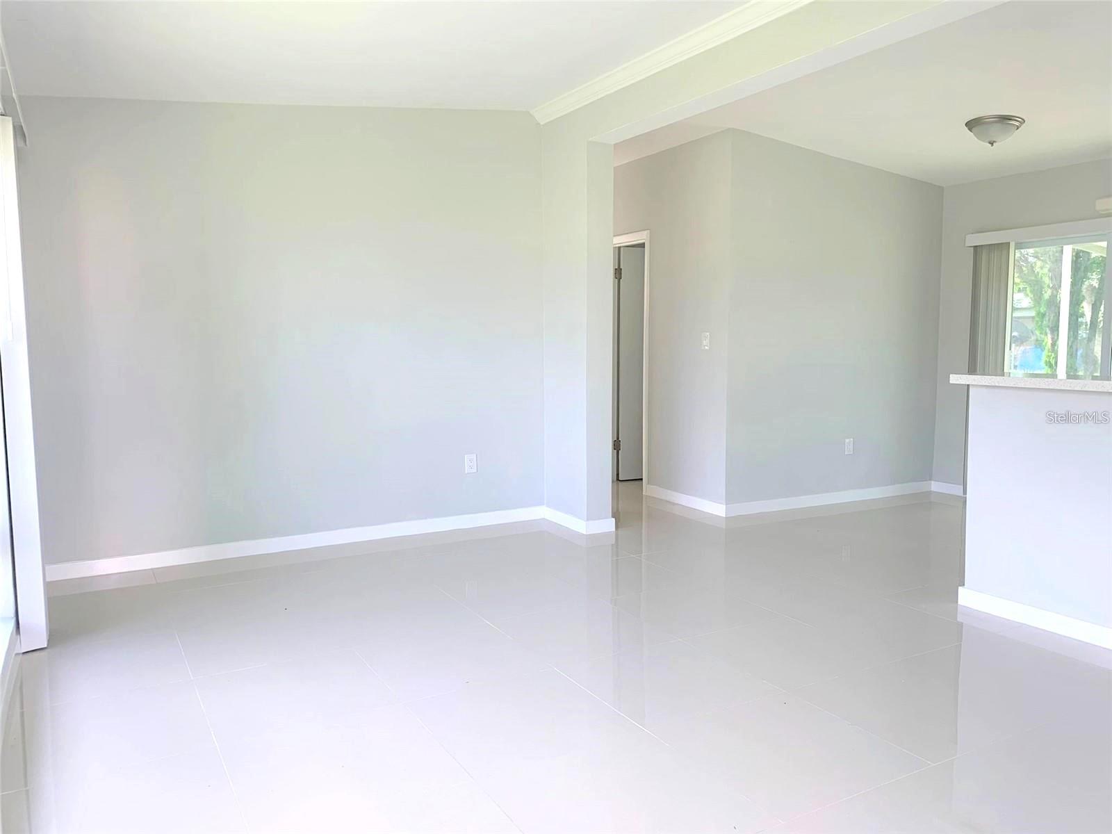 As you walk in you the entrance you are greeted by the livingroom area which features a large window perfect for natural light.