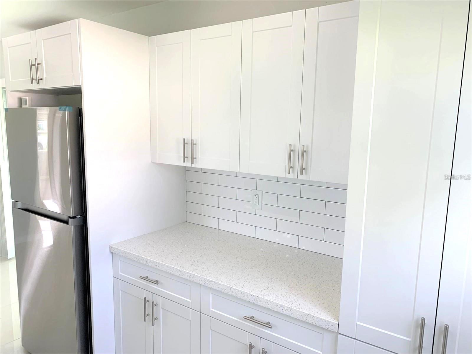 Modern white subway tile backsplash in the galley style kitchen.