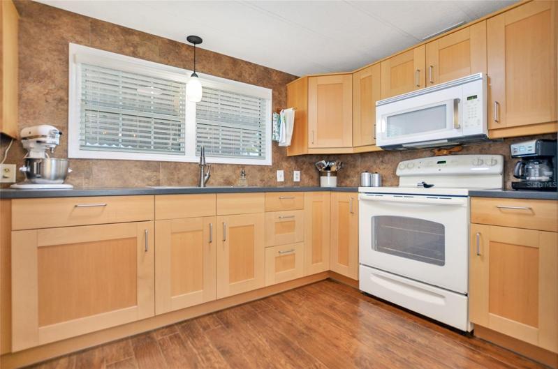 The kitchen has wood floors and cabinets, and lots of storage