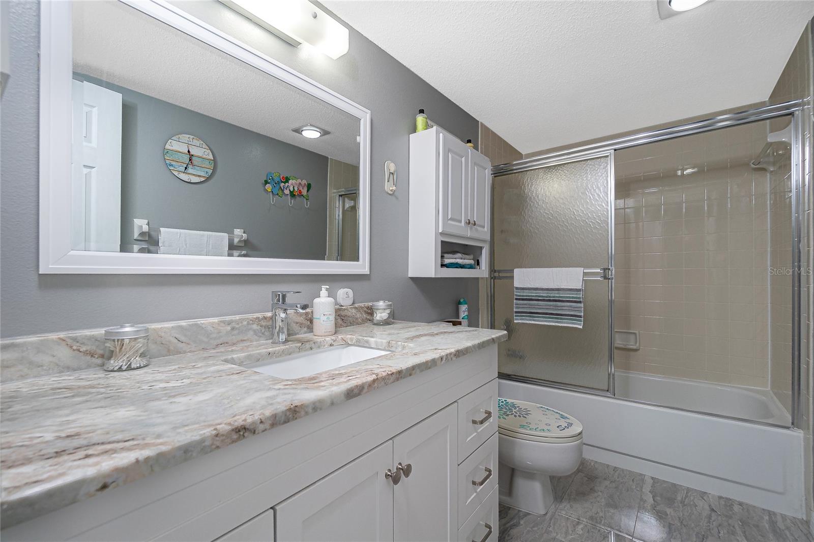 Master bath features an updated vanity, granite countertop, new mirror, and updated toilet.