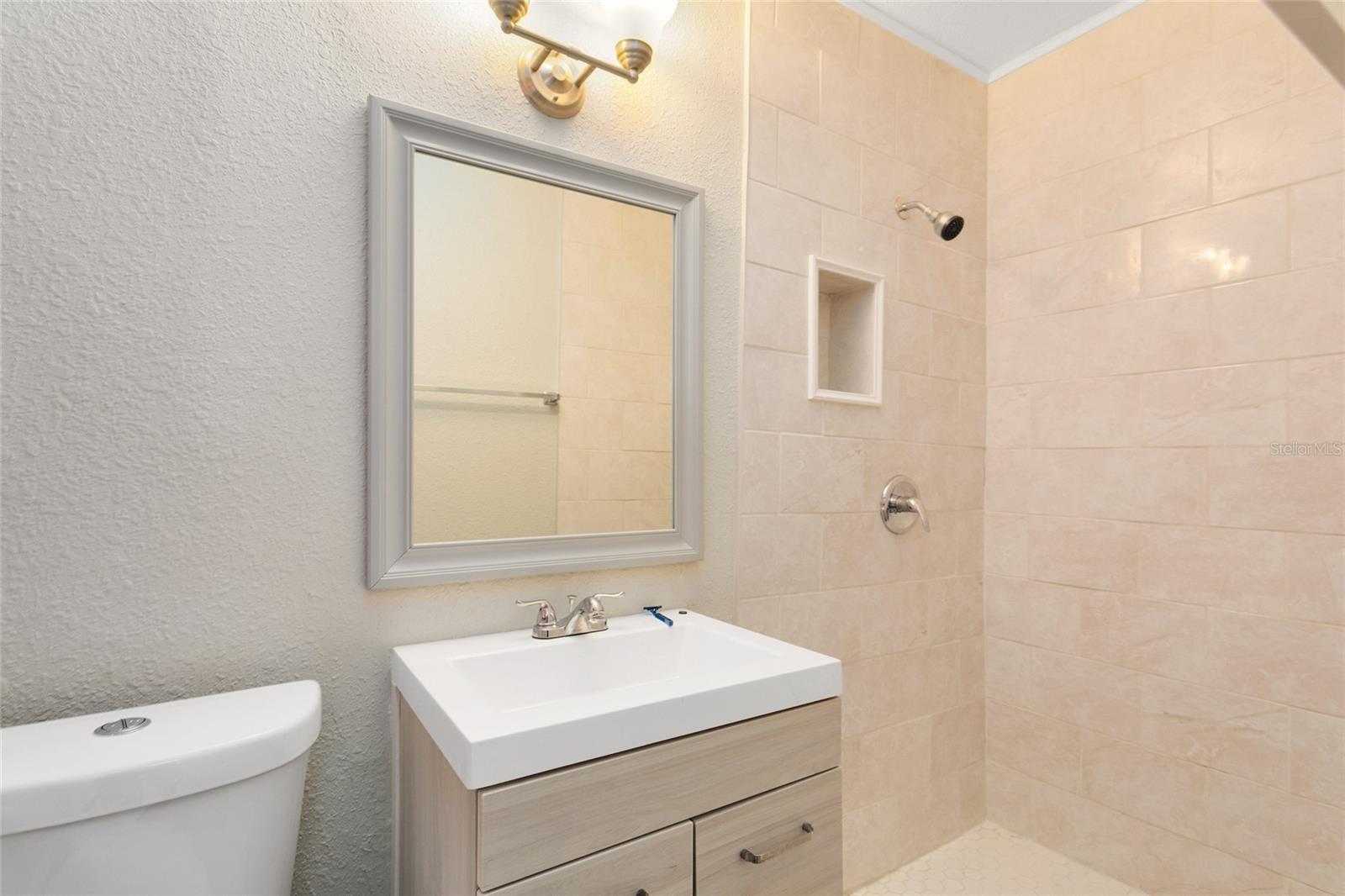 The master bath includes a modern updated vanity and a tiled walk-in shower.