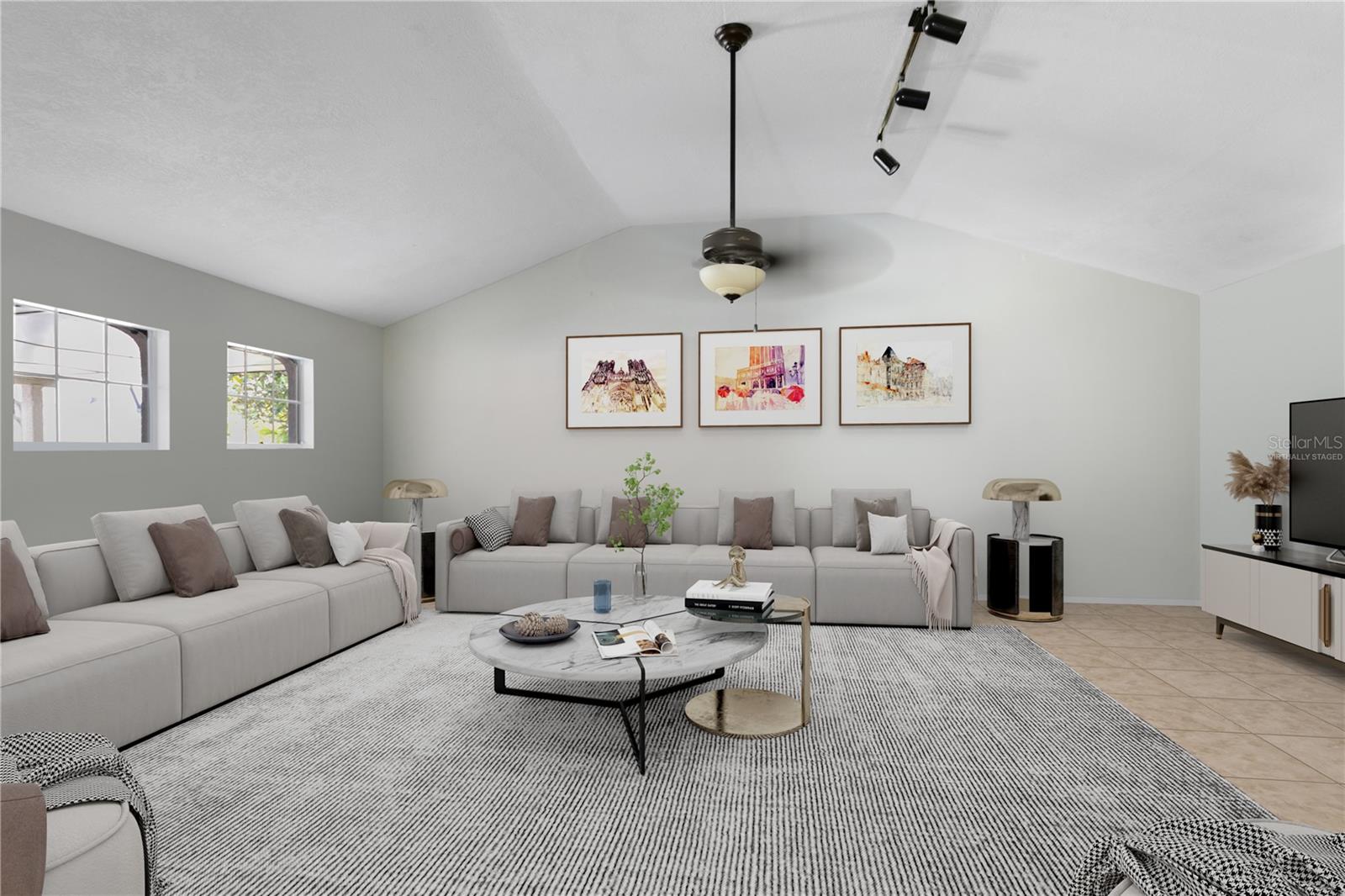 This photo is virtually staged. A large great room boasts a vaulted ceiling, creating an airy and inviting atmosphere.