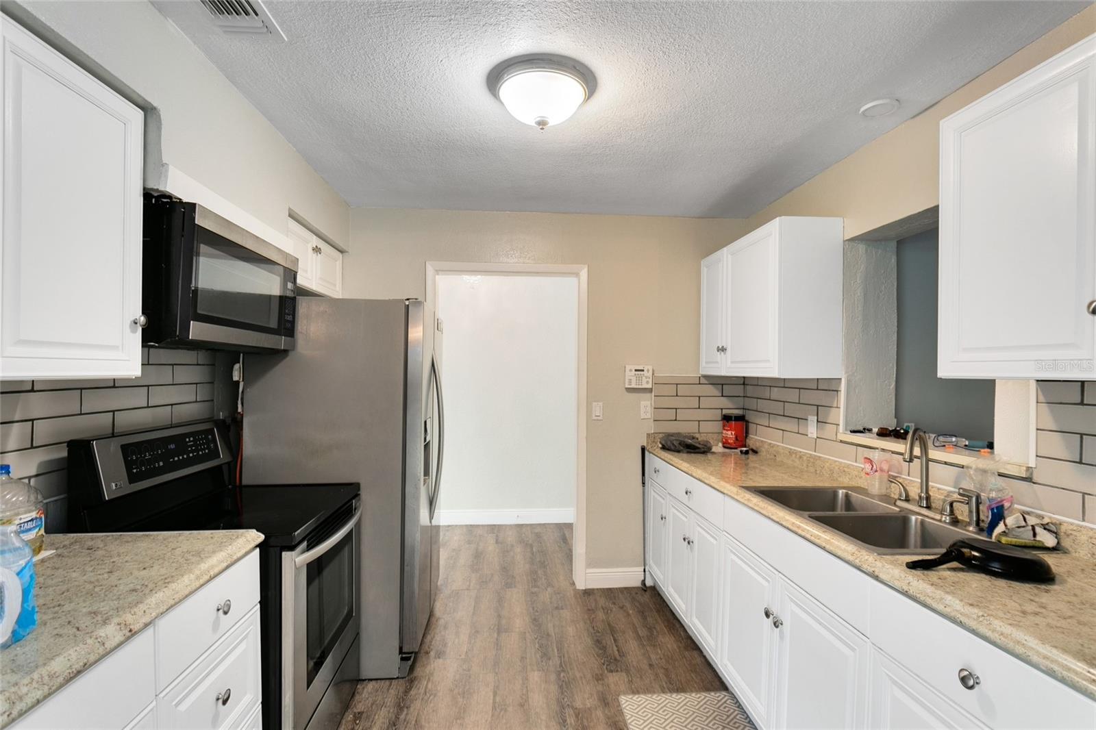 Your beautiful kitchen features GRANITE countertops, STAINLESS STEEL appliances, and a subway tile backsplash.