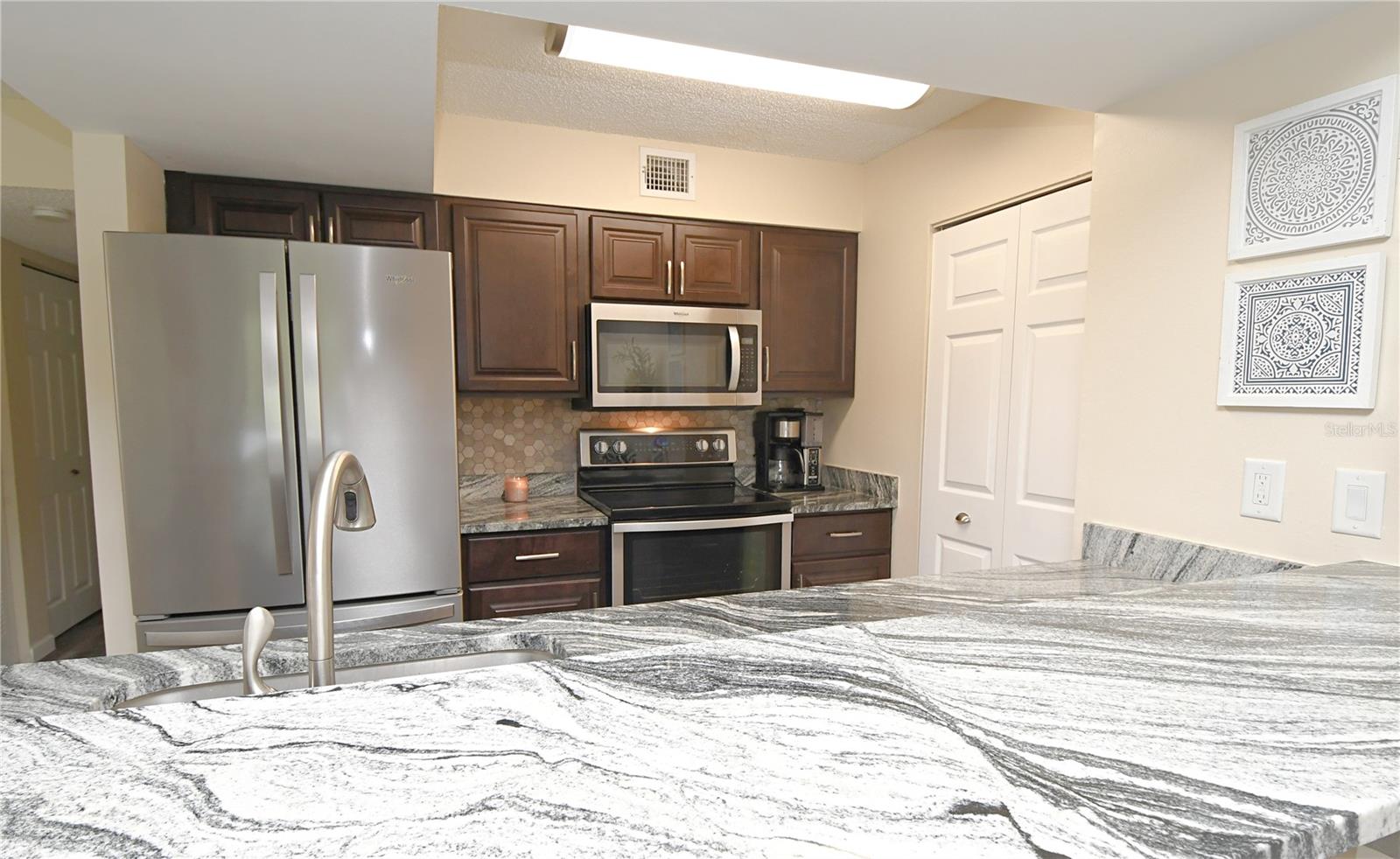 Kitchen featuring granite countertops, breakfast bar, matching stainless steel appliances, and plenty of cabinet space.