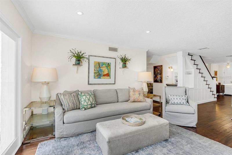 Built-in desk/storage nook behind stairs; Pantry cabinets hidden by pop-out panels along stairway wall.
