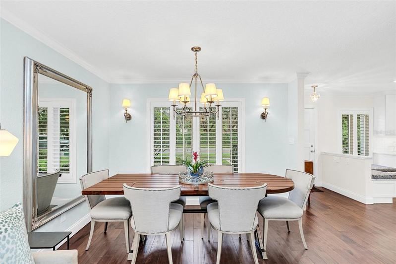 Dining table with views of front lawn and lakefront estates.