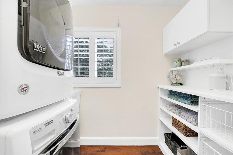 Laundry room- stackable washer/dryer, sink, & custom built-in shelves & drawers for storage.