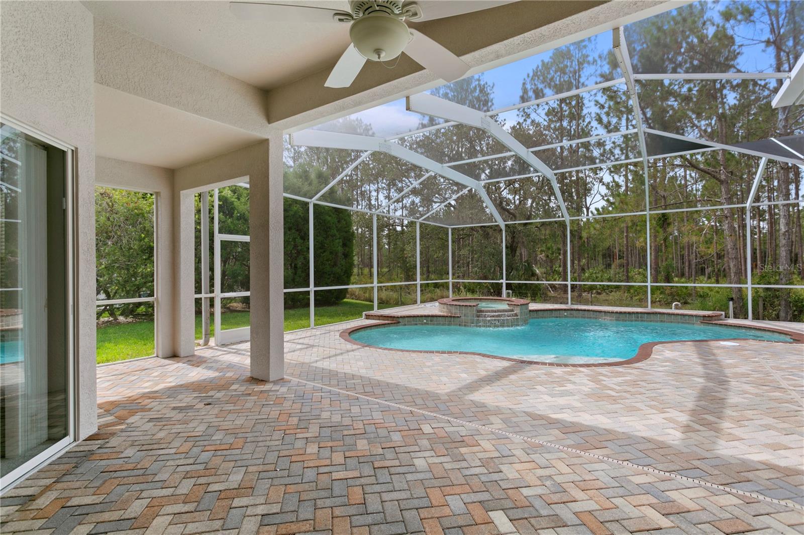 Covered lanai overlooks sparkling pool and stunning conservation