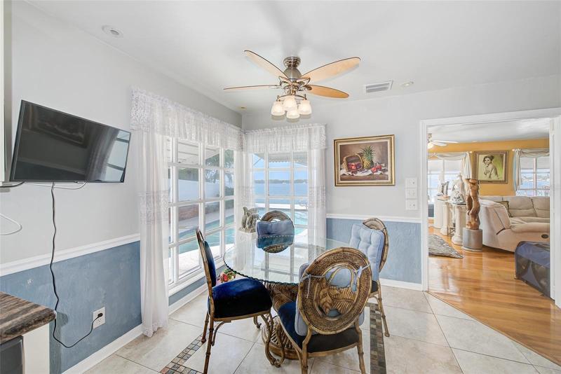 Breakfast nook in kitchen with view of pool and water.