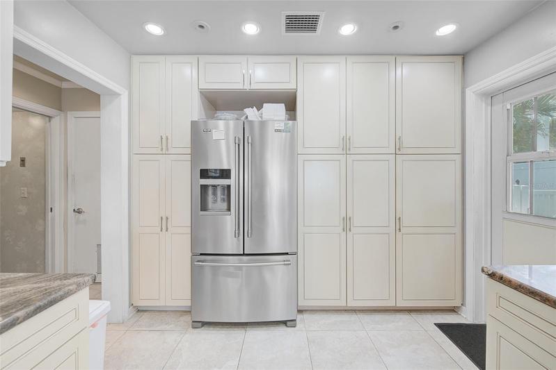 Full wall of cabinets for extra storage.  Door to the right leads to pool area.