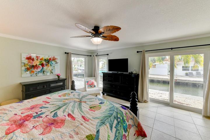 Main bedroom with glassed sliders leading to the backyard with a view of the canal