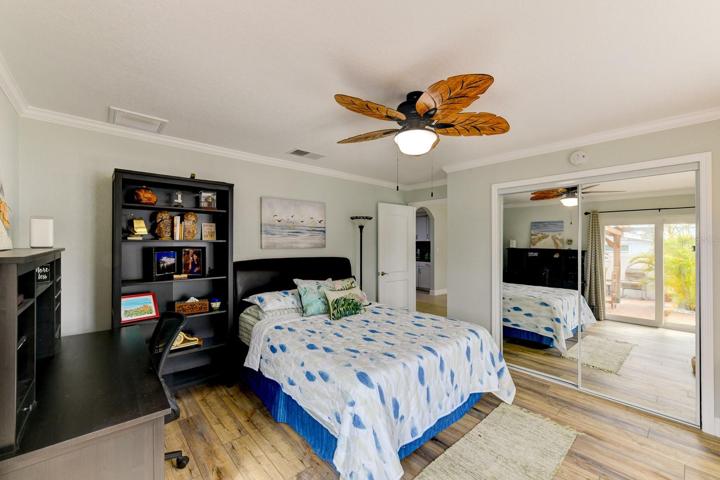 This guest bedroom has an exit to the outdoor kitchen